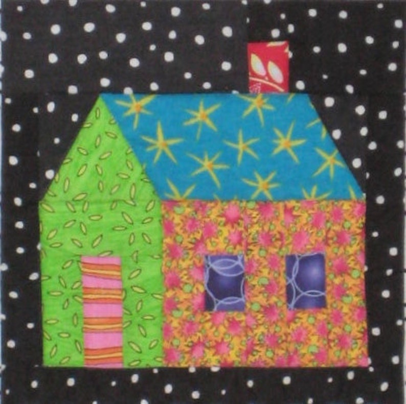 May include: A patchwork house design with a black and white polka dot border. The house has a green side with a door, a floral wall, and a blue roof with yellow star patterns. The chimney is red with a floral pattern.