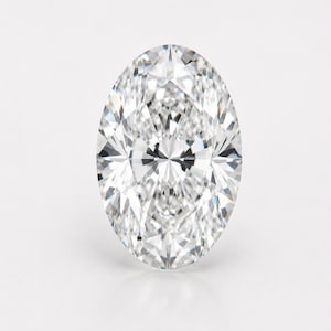 May include: A loose, oval-cut, colourless gemstone featuring a brilliant faceted surface that reflects light with high clarity. The stone displays a symmetrical arrangement of triangular and kite-shaped facets, creating a sharp, sparkling appearance.