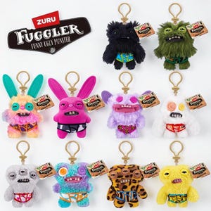 May include: A collection of eleven Zuru Fuggler plush keychains featuring various monster designs with faux fur, button eyes, and teeth. Each character wears patterned underwear and includes a gold-tone metal keyring and a branded tag.