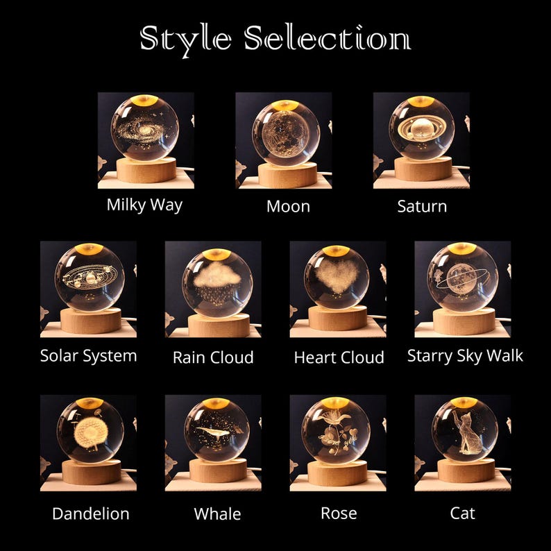 May include: A collection of eleven clear glass spheres with laser-engraved designs including the Milky Way, Moon, Saturn, Solar System, Rain Cloud, Heart Cloud, Starry Sky Walk, Dandelion, Whale, Rose, and Cat, each mounted on a round wooden base.