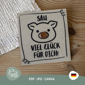 Könnte beinhalten: Eine Karte aus Kraftpapier mit einer schwarzen Umrisszeichnung eines Schweinegesichts und dem deutschen Text "SAU VIEL GLÜCK FÜR DICH!". Eine Kupfermünze befindet sich in der Schnauze des Schweins. Die Karte liegt auf einer Holzoberfläche.