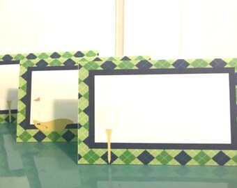 May include: Three green and blue place cards with a golf theme. Each card has a white rectangle in the center with a golf tee and ball graphic.