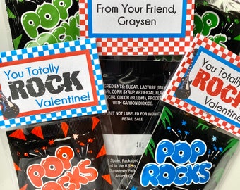 Op de afbeelding: Een Valentijnsdag cadeau-idee met een klein zakje Pop Rocks snoepjes op een rood-blauwe geruite achtergrond en een label met de tekst "You Totally Rock Valentine!"