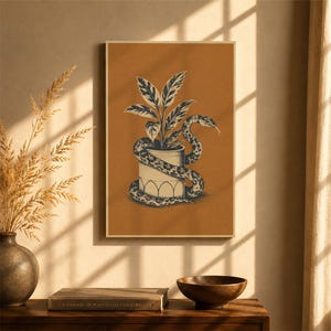 May include: A rectangular wall art print featuring a dark ochre background with a centred illustration of a potted plant. A snake with a detailed scale pattern is coiled around the white cylindrical pot, which has a simple arched base design.