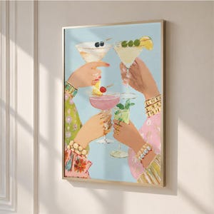Puede incluir: Una lámina de arte mural enmarcada que muestra cuatro manos levantadas en un brindis, cada una sosteniendo una copa de cóctel diferente. Las bebidas incluyen un martini con aceitunas, un cóctel rosa con cereza y una bebida verde con menta sobre fondo azul.