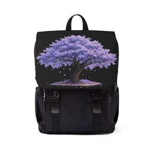 Puede incluir: Una mochila negra con una solapa que presenta un estampado gráfico de un árbol con flores moradas. La mochila tiene un asa superior, dos bolsillos laterales y dos correas con hebilla negras en la parte delantera.