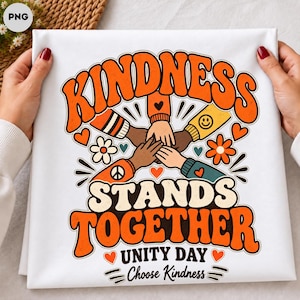 May include: A white t-shirt featuring a graphic with the text KINDNESS STANDS TOGETHER UNITY DAY Choose Kindness. The design shows multiple hands stacked together in the center, surrounded by orange, yellow, and white flowers, hearts, and a peace sign.
