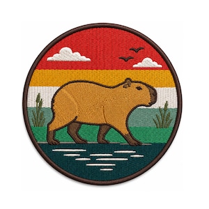 May include: A round patch featuring a capybara walking in front of a lake. The background has a sunset design with red, yellow, and green stripes, white clouds, and three birds. The patch has a brown border.