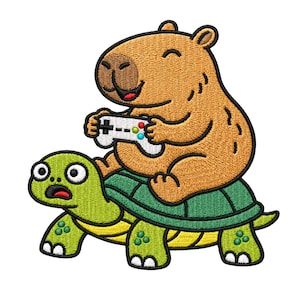 Può includere: Toppa ricamata raffigurante un capibara sorridente che gioca a un videogioco mentre cavalca una tartaruga. Il capibara è marrone, tiene in mano un controller bianco con pulsanti colorati. La tartaruga è verde e gialla, con un'espressione sorpresa.