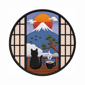 Op de afbeelding: Ronde geborduurde patch met een zwarte kat, een kop koffie en de berg Fuji bij zonsopgang, gezien door een Japanse raam. De patch heeft een zwarte rand. De scène omvat een boom en vogels.