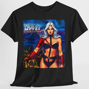 May include: Black t-shirt with a graphic of a woman with white hair and red arm sleeves, holding a weapon. The words "HEAVY METAL" are in silver block letters above the woman. The background is a blue and purple landscape.