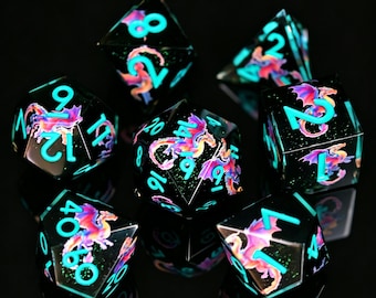 May include: A set of seven black polyhedral dice, each with teal numerals and a colourful dragon design. These dice are for tabletop role-playing games and have a reflective surface.