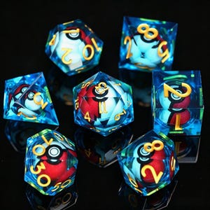 Pode incluir: Conjunto de sete dados poliédricos com tema Pokémon. Cada dado é azul transparente com um design de Poké Bola vermelho e branco no interior. Os números são dourados. Para jogos de tabuleiro.