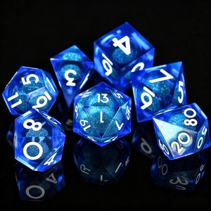 Può includere: Un set di sette dadi poliedrici blu con numeri bianchi. I dadi sono trasparenti, con un interno scintillante e celeste. Sono disposti su una superficie nera riflettente, creando un effetto drammatico. Perfetti per i giochi da tavolo.