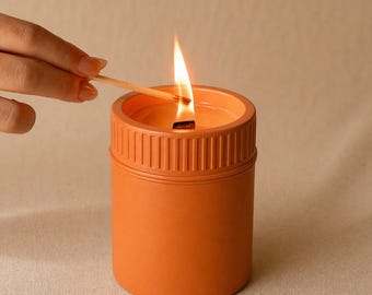 Vela minimalista naranja, vela en frasco de cerámica.