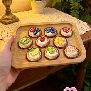 May include: A wooden tray holds nine pixelated mini fruit tarts, each topped with different fruits like blueberries, strawberries, and kiwi. The text "9 Mini Fruit Tart" is at the top. The logo "Puff Bead + Patterns+" is at the bottom.