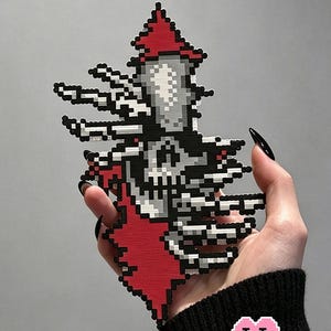 May include: Pixelated skull design in black, white, and red, held against a gray background. The skull has a red pointed hat and outstretched pixelated arms. The text "Space-Rending Skull" is at the top, and "Puff Bead + Patterns+" is at the bottom.