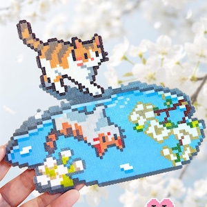 Puede incluir: Un diseño pixelado de gato atigrado con el texto "Spring Water Reflects Tabby Cat" y "Puff Bead Patterns". El gato es naranja, blanco y marrón, sobre un fondo de agua azul con flores blancas.