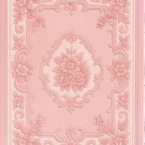 May include: A pink, textured, floral-patterned rug with a rectangular design. The rug features a central floral bouquet and ornate corner and border designs in a lighter pink hue. The overall aesthetic is vintage and elegant.