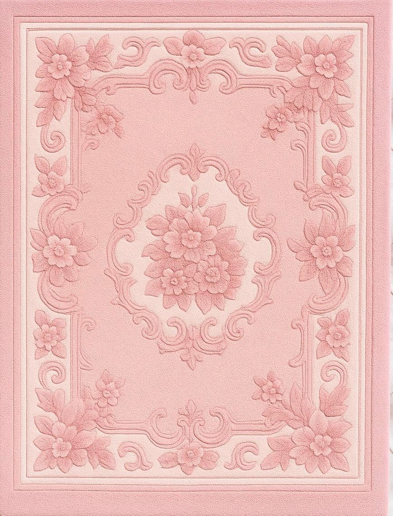 May include: A pink, textured, floral-patterned rug with a rectangular design. The rug features a central floral bouquet and ornate corner and border designs in a lighter pink hue. The overall aesthetic is vintage and elegant.