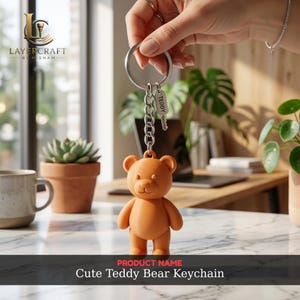 Könnte beinhalten: Ein niedlicher, orangefarbener Teddybär-Schlüsselanhänger mit einer silbernen Kette und einem Schlüsselanhänger mit der Aufschrift "TEDDY". Der Schlüsselanhänger wird von einer Hand gehalten. Der Produktname "Cute Teddy Bear Keychain" wird unten im Bild angezeigt.