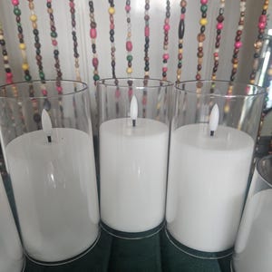 Velas blancas parpadeantes sin llama que funcionan con pilas. Incluye mando a distancia y temporizador.