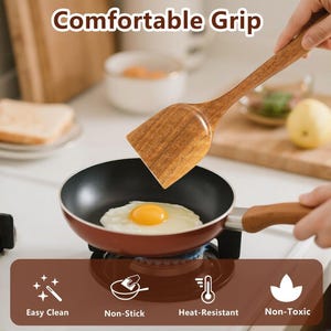 May include: A wooden spatula with a rectangular head is held over a small red and black frying pan with a fried egg. The image includes the text "Comfortable Grip", "Easy Clean", "Non-Stick", "Heat-Resistant", and "Non-Toxic".