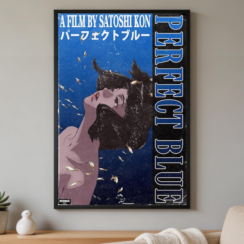 K&ouml;nnte beinhalten: Ein rechteckiges Wandposter zum Anime-Film Perfect Blue von Satoshi Kon. Das Kunstwerk zeigt eine Person mit dunklem Haar, die in tiefblauem Wasser von kleinen Goldfischen umgeben ist, mit dem aufgedruckten Text A Film By Satoshi Kon und Perfect Blue.