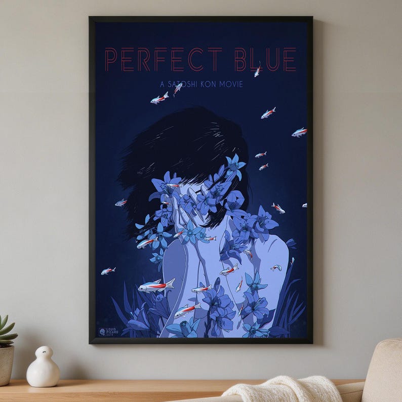 K&ouml;nnte beinhalten: Ein gerahmtes Filmplakat f&uuml;r Perfect Blue von Satoshi Kon mit dunkelblauem Hintergrund, einer zentralen Figur, die von blauen Blumen verdeckt wird, und kleinen schwimmenden Fischen. Der Text Perfect Blue und A Satoshi Kon Movie steht oben in Rot.