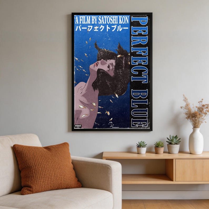 K&ouml;nnte beinhalten: Ein gerahmtes vertikales Filmplakat f&uuml;r Perfect Blue von Satoshi Kon. Das Kunstwerk zeigt einen dunkelblauen Hintergrund mit einer nach oben blickenden Person, umgeben von kleinen Goldfischen. Der Text lautet A FILM BY SATOSHI KON, PERFECT BLUE.