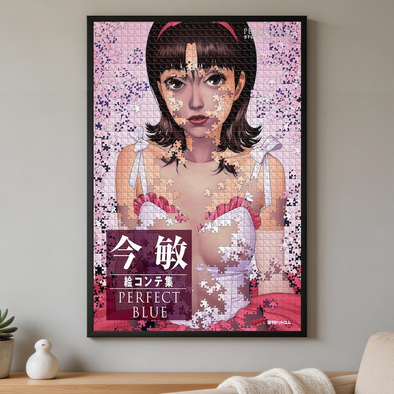 K&ouml;nnte beinhalten: Ein gerahmtes Puzzle mit einer Anime-Illustration einer Person mit dunklem Haar und einem rosa Stirnband. Das Bild ist teilweise in Puzzleteile zerlegt und vor einem rosa Blumenhintergrund platziert. Der Text umfasst "今敏", "絵コンテ集" und "PERFECT BLUE".