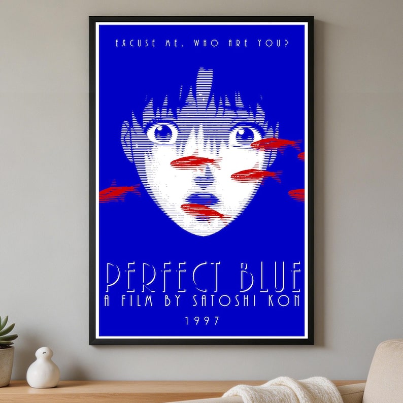 K&ouml;nnte beinhalten: Ein gerahmtes Poster zum Film Perfect Blue mit einem leuchtend blauen Hintergrund und einem stilisierten wei&szlig;en Linienportr&auml;t eines Gesichts. Rote Fischsilhouetten sind &uuml;ber das Gesicht gelegt. Der Text lautet: EXCUSE ME, WHO ARE YOU? PERFECT BLUE A FILM BY SATOSHI KON 1997.