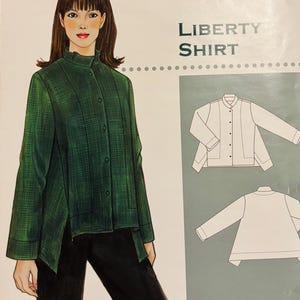 May include: The Sewing Workshop Liberty Shirt sewing pattern envelope features an illustration of a person wearing a dark green long-sleeved shirt with a high collar and button front, alongside line drawings of the front and back of the shirt.