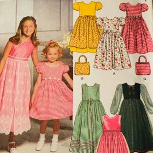 Könnte beinhalten: Simplicity-Schnittmuster mit Mädchenkleidern in verschiedenen Stilen und Farben, darunter gelbe, rot-karierte, florale und grün gestreifte Designs. Das Muster enthält ein rosa Kleid mit Spitzensaum und ein schwarz-grünes Kleid mit langen Ärmeln. Zwei junge Mädchen tragen Kleider.