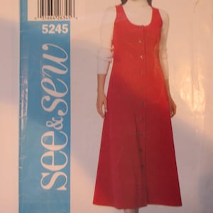 Può includere: Un abito rosso con bottoni e un top a collo alto bianco sotto. L'abito ha una silhouette semplice e a linea A ed è realizzato in un tessuto morbido e confortevole. Il modello è per la taglia C/18-20-22 e il numero del modello è 5245.
