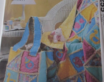Puede incluir: Patrón de manualidades McCall's Crafts número 4233 para una colcha y una bolsa de bebé. La colcha está hecha de cuadrados de patchwork en amarillo, azul, rosa y verde con un borde de crochet blanco. La bolsa está hecha del mismo tejido y tiene un asa de crochet.