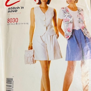 Puede incluir: Patrón de costura vintage con dos conjuntos. Uno es un chaleco y pantalones cortos blancos, el otro un chaleco floral con una falda azul. El patrón está etiquetado como "Easy stitch 'n save by McCall's" y talla B [12-14-16-18].