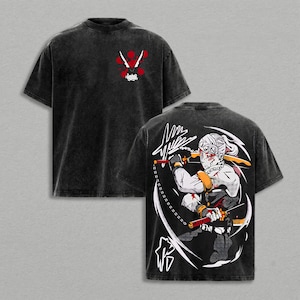 May include: Black t-shirt with a distressed wash. The front features a red and white graphic. The back displays a detailed illustration of a character with swords and a chain, in black, white, red, and yellow.