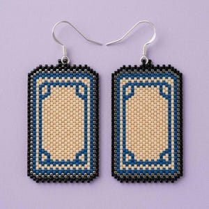 May include: A pair of rectangular drop earrings crafted from small beads. The design features a central beige panel surrounded by a blue border and a black outer edge. Each earring hangs from a silver-toned metal hook for pierced ears.