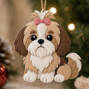 Può includere: Un ornamento a forma di cane Shih Tzu in feltro con un fiocco rosa. Il cane ha pelo marrone, beige e bianco, grandi occhi neri e un naso nero. L'ornamento è progettato con pezzi di feltro a strati e un cordino per appenderlo. Una decorazione festiva per le vacanze.
