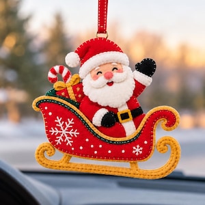 Peut inclure: Une décoration suspendue en feutrine représentant le Père Noël dans un traîneau rouge à bordure jaune. Le Père Noël porte un costume rouge avec une barbe blanche et des gants noirs. Le traîneau est orné de flocons blancs et d'un cadeau.