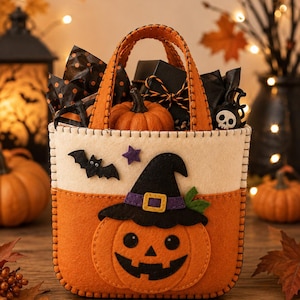 Può includere: Un sacchetto per dolcetti di Halloween in feltro con parte superiore color crema e base arancione, uniti da cuciture nere visibili. Il lato anteriore presenta una zucca sorridente con un cappello da strega nero e una piccola stella viola.