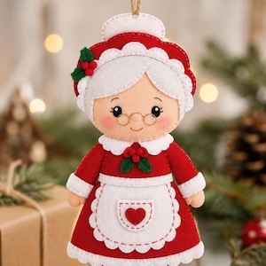 Peut inclure: Une décoration en feutrine représentant une grand-mère vêtue d'une robe rouge avec un tablier blanc festonné, un col blanc et un bonnet blanc. La figurine présente des feuilles de houx vertes avec des baies rouges, des lunettes et un cœur rouge.