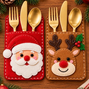 May include: Two rectangular felt cutlery holders featuring a Santa Claus face on a red background and a reindeer face on a brown background. Each holder contains a gold-toned fork, knife, and spoon tucked into a top pocket with white stitching.