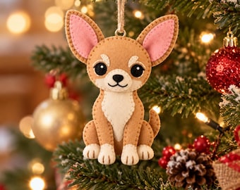 May include: A felt chihuahua ornament featuring a tan body, a cream-colored chest and paws, and large pink-lined ears. The dog has black eyes, a black nose, and a stitched mouth. It hangs from a jute string, showcasing visible tan stitching.