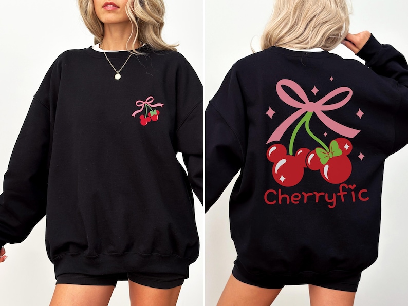 May include: A black long-sleeve sweatshirt featuring a small graphic of two red cherries shaped like mouse heads with a pink bow on the front left chest and a large matching graphic on the back with the text Cherryfic in red lettering.