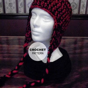 Puede incluir: Un gorro de punto negro y rojo con largas cintas trenzadas. El gorro tiene una parte superior puntiaguda y orejeras. El texto "CROCHET PATTERN" es visible en un círculo blanco.