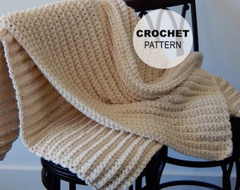 May include: A crocheted blanket in a cream color, draped over a chair. The blanket has a ribbed texture and is made with a single crochet stitch. The text "CROCHET PATTERN" is visible in a circle on the blanket.