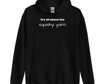 May include: Black hooded sweatshirt with a white graphic that says "It's all about the squishy yarn."