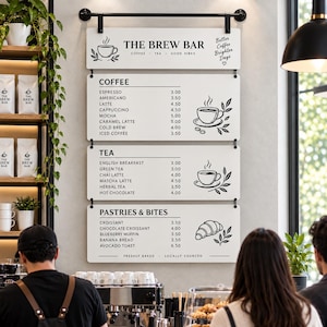 May include: A white rectangular menu board titled THE BREW BAR with black text listing coffee, tea, and pastry items with prices. The sign features line art illustrations of coffee cups and a croissant, with the text Better Coffee Brighter Days.